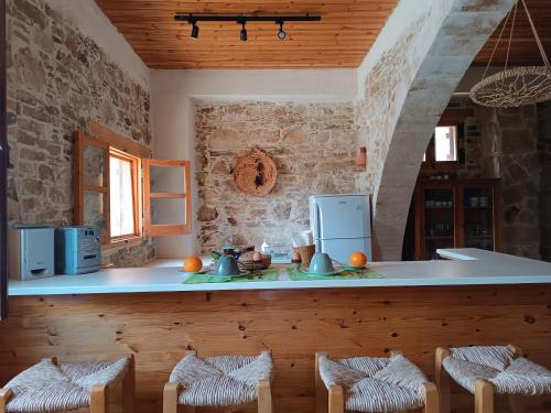 a kitchen with a counter and chairs in a room at The House of Pericles in Silikou