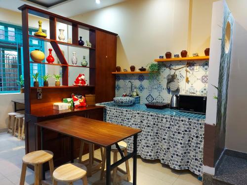 胡志明市的住宿－Northern Hostel - Bui Vien Walking Street，厨房配有桌子和带凳子的台面