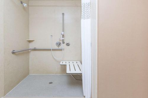 - une cabine de douche avec un banc dans la salle de bains dans l'établissement Hampton Inn & Suites Yuba City, à Yuba City