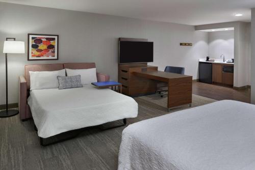 a hotel room with a bed and a desk with a computer at Hampton Inn & Suites Montreal-Dorval in Dorval