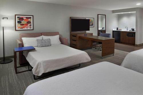 a hotel room with two beds and a desk at Hampton Inn & Suites Montreal-Dorval in Dorval