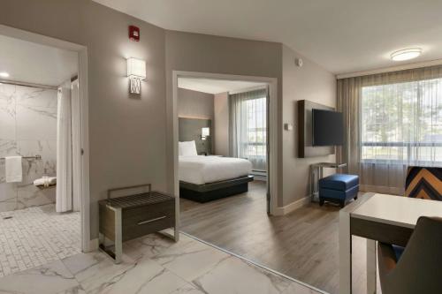 ポイントクレアにあるEmbassy Suites By Hilton Montreal Airportのベッドとバスルーム付きのホテルルームです。