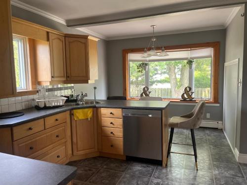 ウェランドにあるMy Own Homeのキッチン(木製キャビネット、シンク、窓付)