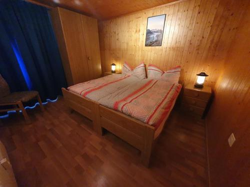 1 dormitorio con 1 cama en una habitación de madera en First : ski-out for 4 in the central Chalet Diana, en Bettmeralp