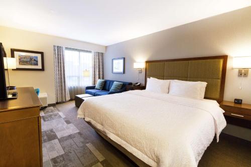 a hotel room with a large bed and a couch at Hampton Inn - Vancouver Airport/Richmond in Richmond