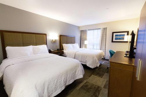une chambre d'hôtel avec deux lits et une télévision dans l'établissement Hampton Inn - Vancouver Airport/Richmond, à Richmond