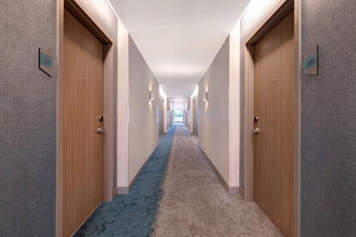 a corridor of a hallway with doors and a long aisle at Home2 Suites By Hilton Montreal Dorval in Dorval