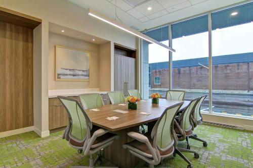 a conference room with a wooden table and chairs at Home2 Suites By Hilton Montreal Dorval in Dorval