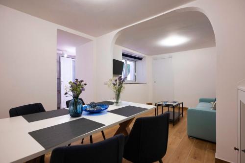 una sala da pranzo con tavolo e sedie bianchi di Diomira Apartment a Taormina