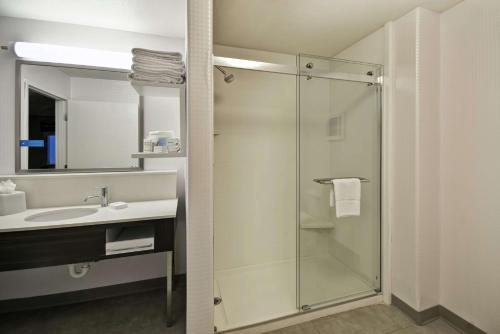 a bathroom with a glass shower and a sink at Hampton Inn & Suites Yuma in Yuma