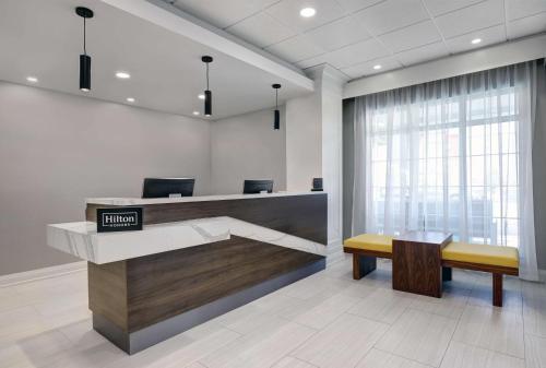 an office lobby with a reception desk and a bench at Homewood Suites by Hilton London Ontario in London