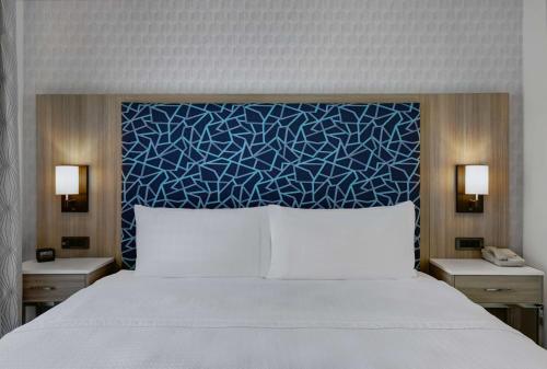 a bedroom with a bed with a blue head board at Homewood Suites by Hilton London Ontario in London