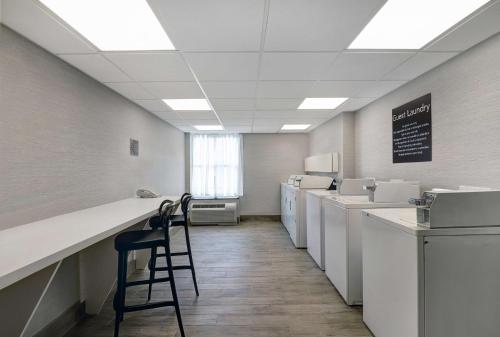 a laundry room with machines and a bar with a chair at Homewood Suites by Hilton London Ontario in London