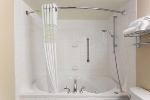 El baño incluye bañera blanca con cortina de ducha. en Hampton Inn & Suites, by Hilton - Vancouver Downtown, en Vancouver