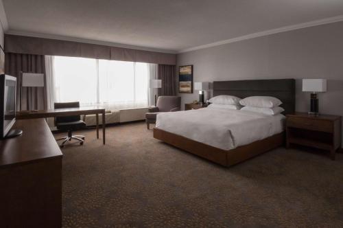 a large hotel room with a bed and a desk at Doubletree by Hilton London in London