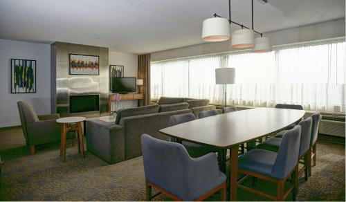 a living room with a couch and a table and chairs at Doubletree by Hilton London in London