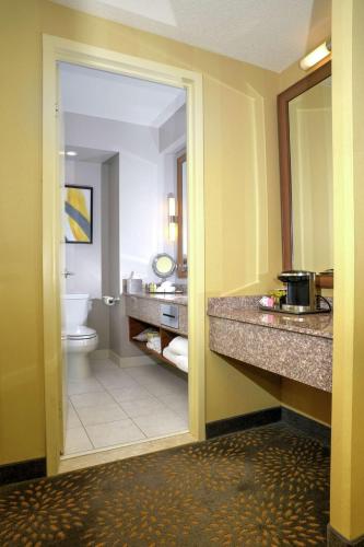 a bathroom with a toilet and a sink and a mirror at Doubletree by Hilton London in London