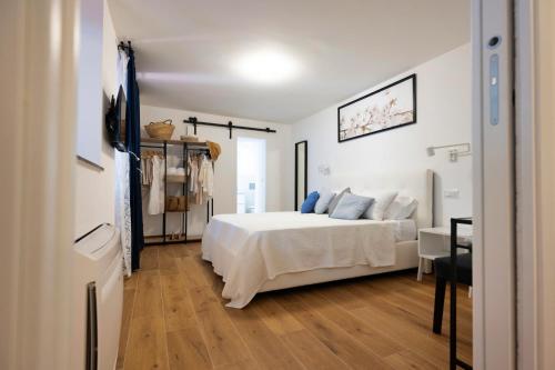 a bedroom with a white bed and a desk at Diomira Apartment in Taormina