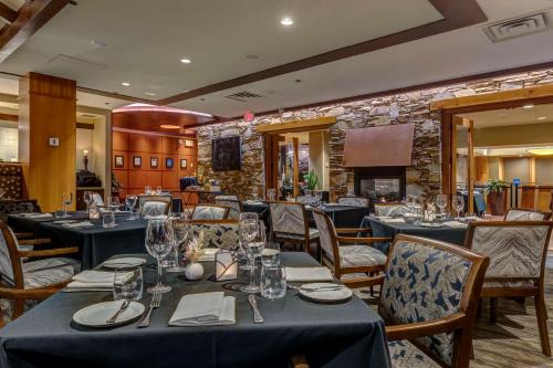 a restaurant with blue tables and chairs and a stone wall at Hilton Whistler Resort & Spa in Whistler