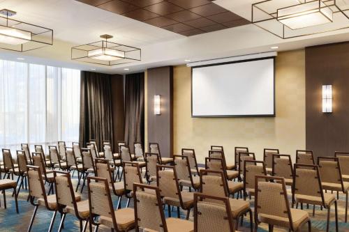 a conference room with chairs and a projection screen at Hilton Garden Inn Calgary Downtown in Calgary