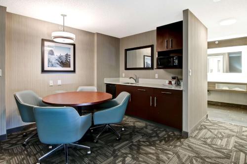 a kitchen and dining room with a table and chairs at Hampton Inn & Suites by Hilton Calgary-Airport in Calgary