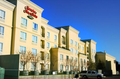 a white car parked in front of a building at Hampton Inn & Suites by Hilton Calgary University NW in Calgary