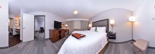 a hotel room with a bed with a purse on it at Hampton Inn & Suites by Hilton Calgary University NW in Calgary