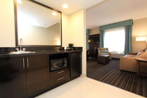 a bathroom with a sink and a living room at Hampton Inn & Suites by Hilton St. John's Airport in St. John's