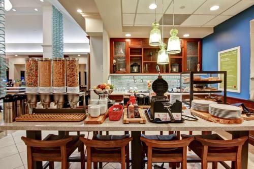 a restaurant with a table with chairs and plates at Hilton Garden Inn Toronto/Burlington in Burlington