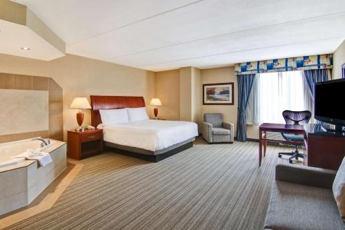 a hotel room with a bed and a bathroom at Hilton Garden Inn Toronto/Burlington in Burlington