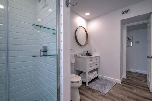 a bathroom with a toilet and a sink and a mirror at Bean Point Residence in Anna Maria