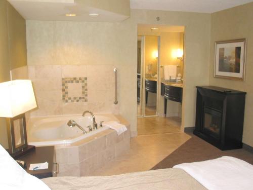 Homewood Suites by Hilton Toronto-Markham في ماركهام: حمام مع حوض استحمام ومدفأة