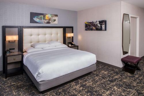 a bedroom with a large white bed and a mirror at DoubleTree by Hilton Utica in Utica