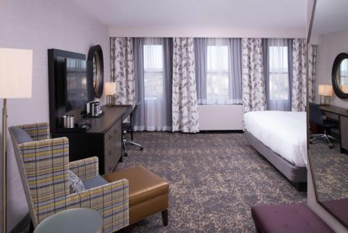 a hotel room with a bed and a desk at DoubleTree by Hilton Utica in Utica