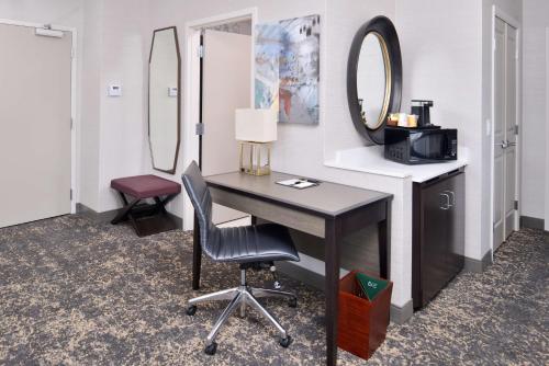 a room with a desk and a chair and a mirror at DoubleTree by Hilton Utica in Utica