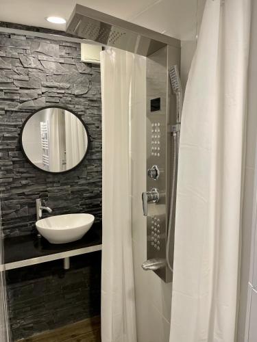 une salle de bain avec un lavabo et un miroir dans l'établissement Studio au calme climatisé avec terrasse, à Paillet