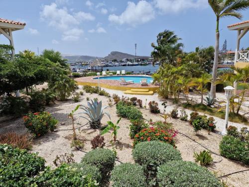 un jardín con plantas y una piscina en Luxury appt for 6: mesmerizing Spanish water view, en Jan Thiel