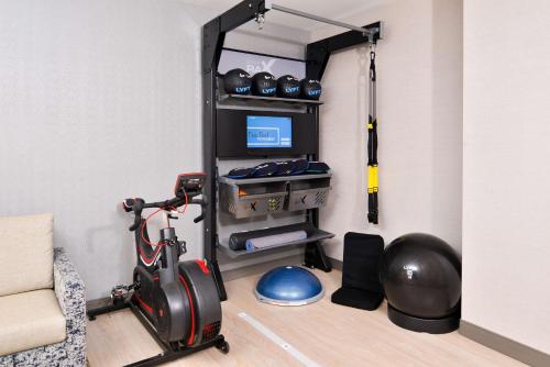 a living room with a room with a treadmill and a room with a room at DoubleTree by Hilton Utica in Utica