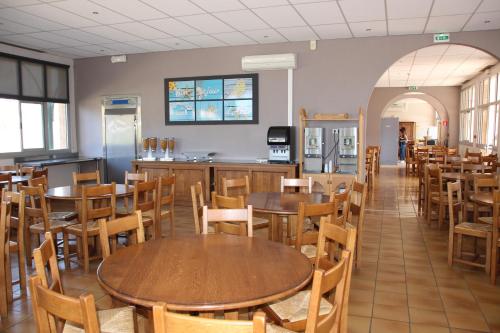 un restaurant avec des tables et des chaises et une cuisine dans l'établissement Les Voiles d'Azur, à La Londe-les-Maures