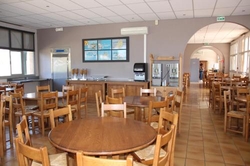 a restaurant with tables and chairs and a kitchen at Les Voiles d'Azur in La Londe-les-Maures