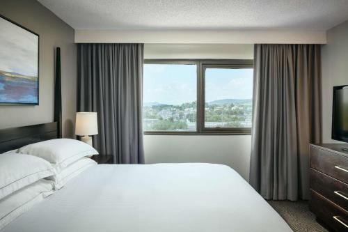 um quarto de hotel com uma cama grande e uma janela em Hilton Suites Brentwood em Brentwood