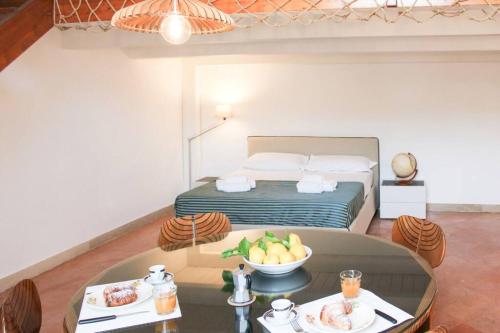 Zimmer mit einem Bett und einem Tisch mit einer Obstschale in der Unterkunft H.Verde Sorrento Apartment in Sant'Agnello