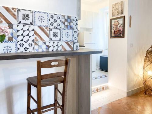 eine Küche mit einer Theke und einem Holzstuhl in der Unterkunft H.Verde Sorrento Apartment in Sant'Agnello