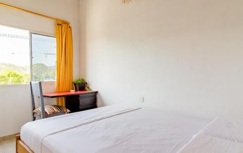1 dormitorio con cama, escritorio y ventana en red moon, en Santa Marta