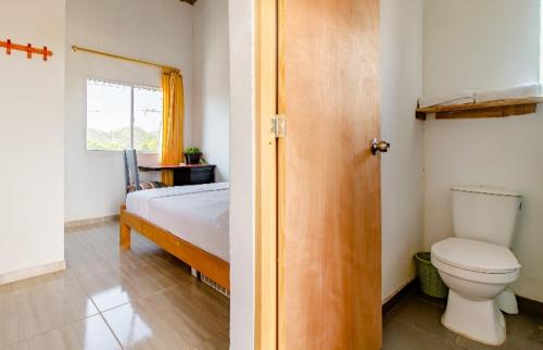 a bathroom with a bed and a toilet in a room at red moon in Santa Marta