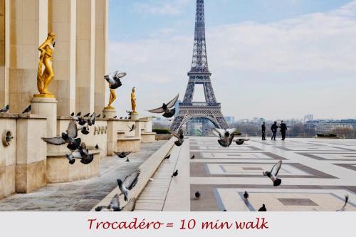 a flock of pigeons in front of the eiffel tower at La Maison Kléber - Luxury apartments, Champs-Elysées - Eiffel Tower in Paris