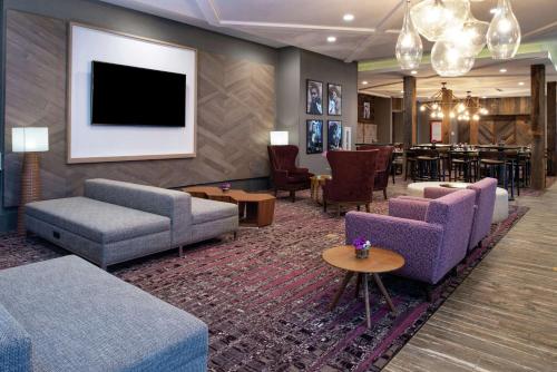 a lobby with couches and a tv and a table at Hilton Garden Inn Gallatin in Gallatin