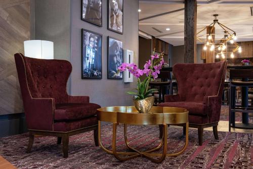 a lobby with two chairs and a table with flowers on it at Hilton Garden Inn Gallatin in Gallatin