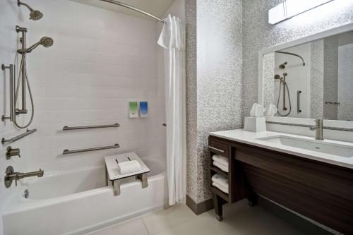 a bathroom with a tub and a sink and a shower at Home2 Suites By Hilton Jekyll Island in Jekyll Island