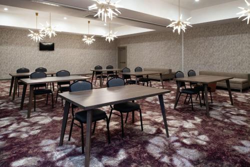 a conference room with tables and chairs and chandeliers at Hilton Garden Inn Gallatin in Gallatin